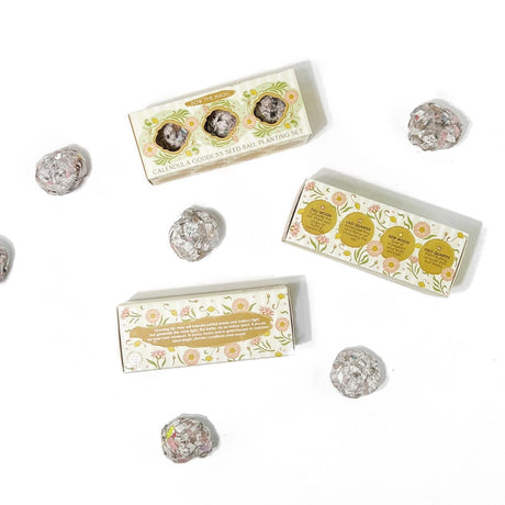 a trio of seed ball sets on a white background with seed balls scattered about them