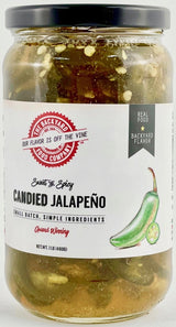 A jar of Backyard Candied Jalapeño from Backyard Food Company, featuring a white label with red and black text, a black lid, and visible sliced jalapeños and garlic in the brine.
