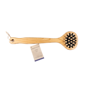 Wooden brush with black bristles and a card on a white background