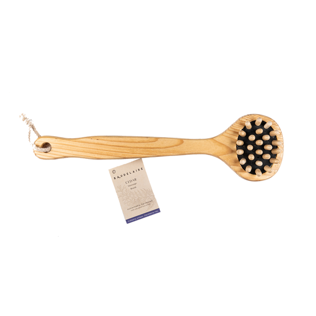 Wooden brush with black bristles and a card on a white background