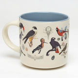 a white coffee mug with vintage illustrations of birds wrapping around it, and a solid sky blue print on the inside of the mug