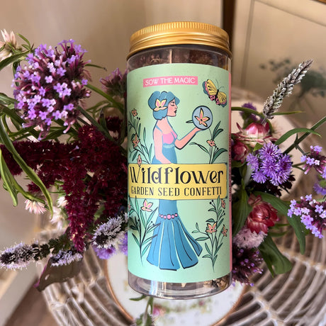 Bottle of Wildflower Garden Seed Confetti with decorative label surrounded by flowers