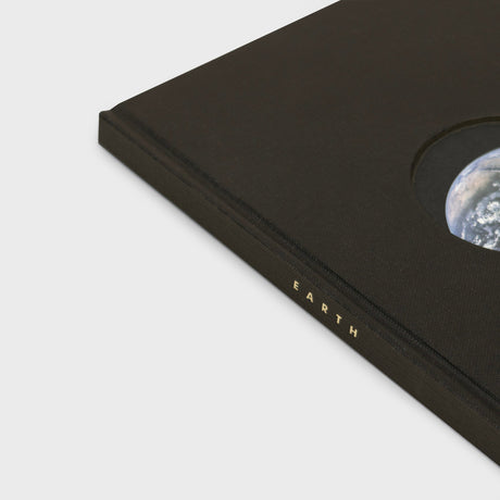 Black book with 'EARTH' embossed on it, featuring a circular cutout revealing Earth.