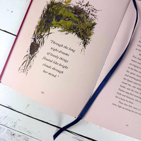 Open book with pink pages, decorative bookmark and illustration on a wooden surface