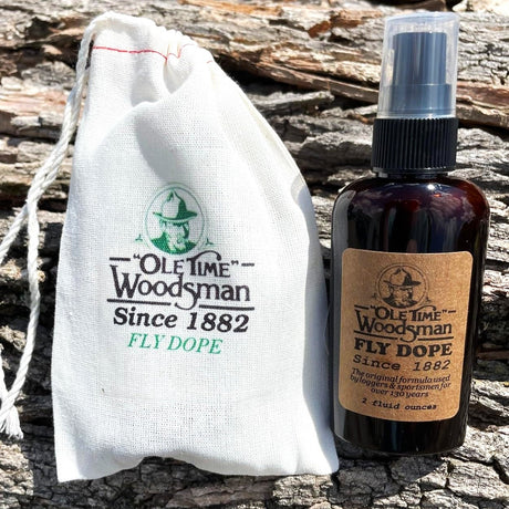 a bottle of ole time woodsman fly dope on a log