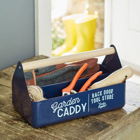 the blue garden caddy on a wood tabletop and filled with miscellaneous tools