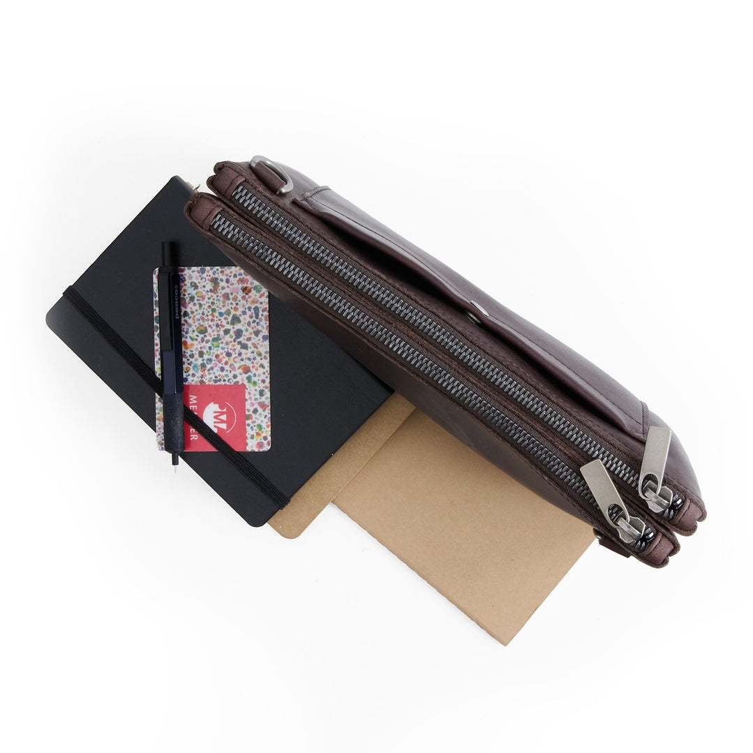 Black and brown zipper pouches with a card and paper on a white background