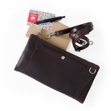 Brown leather pouch with strap and accessories on a white background
