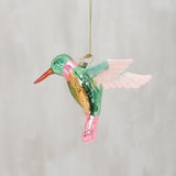 Colorful glass hummingbird ornament on a plain background