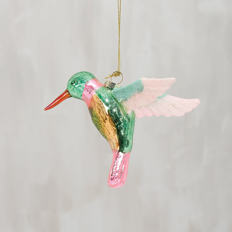 Colorful glass hummingbird ornament on a plain background