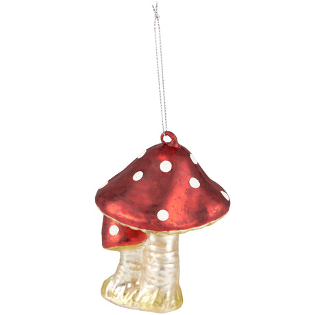 A red and white spotted mushroom Christmas ornament with a textured clear stem and a silver hanging string, shown against a plain white background.