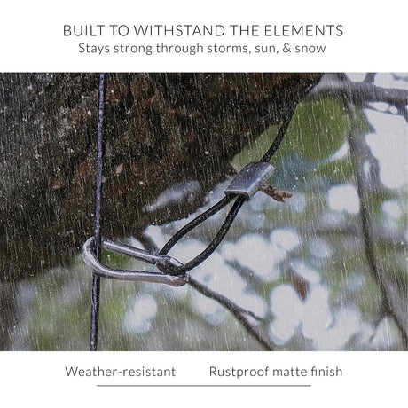 Close up of the hanging hook looped around a tree branch in the pouring rain with the text - "Built to withstand the elements - stays strong through storms, sun, and snow. Weather-resistant, rustproof matte finish"