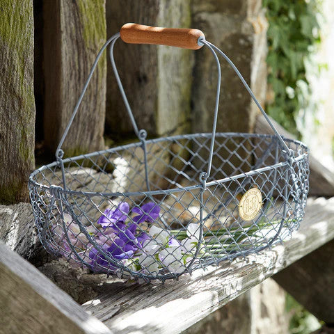 the large harvest basket resting on rustic wooden steps and filled with white and purple flowers