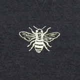 White printed bee design on a dark fabric background