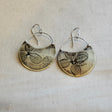 Pair of earrings with pressed hydrangea petal designs on a textured fabric background