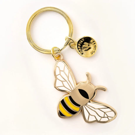 Gold bee-shaped keychain on a white background