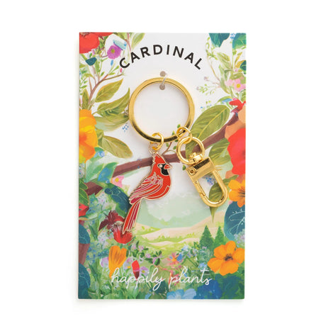 Cardinal keychain on a colorful nature-themed card with 'happily plants' branding.