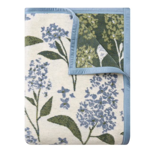 Floral patterned blanket with blue and green colors on a white background