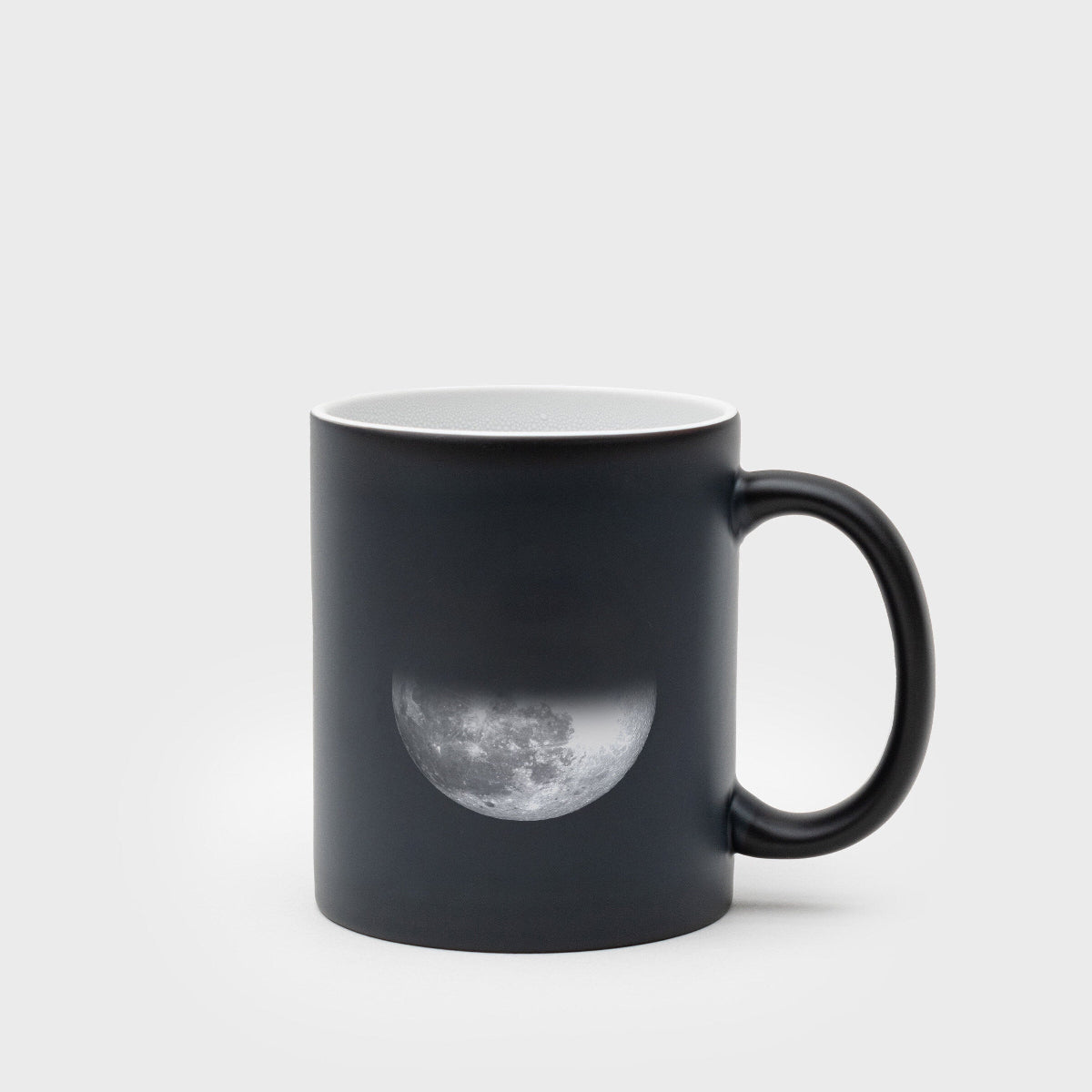 Black mug with a moon design on a white background
