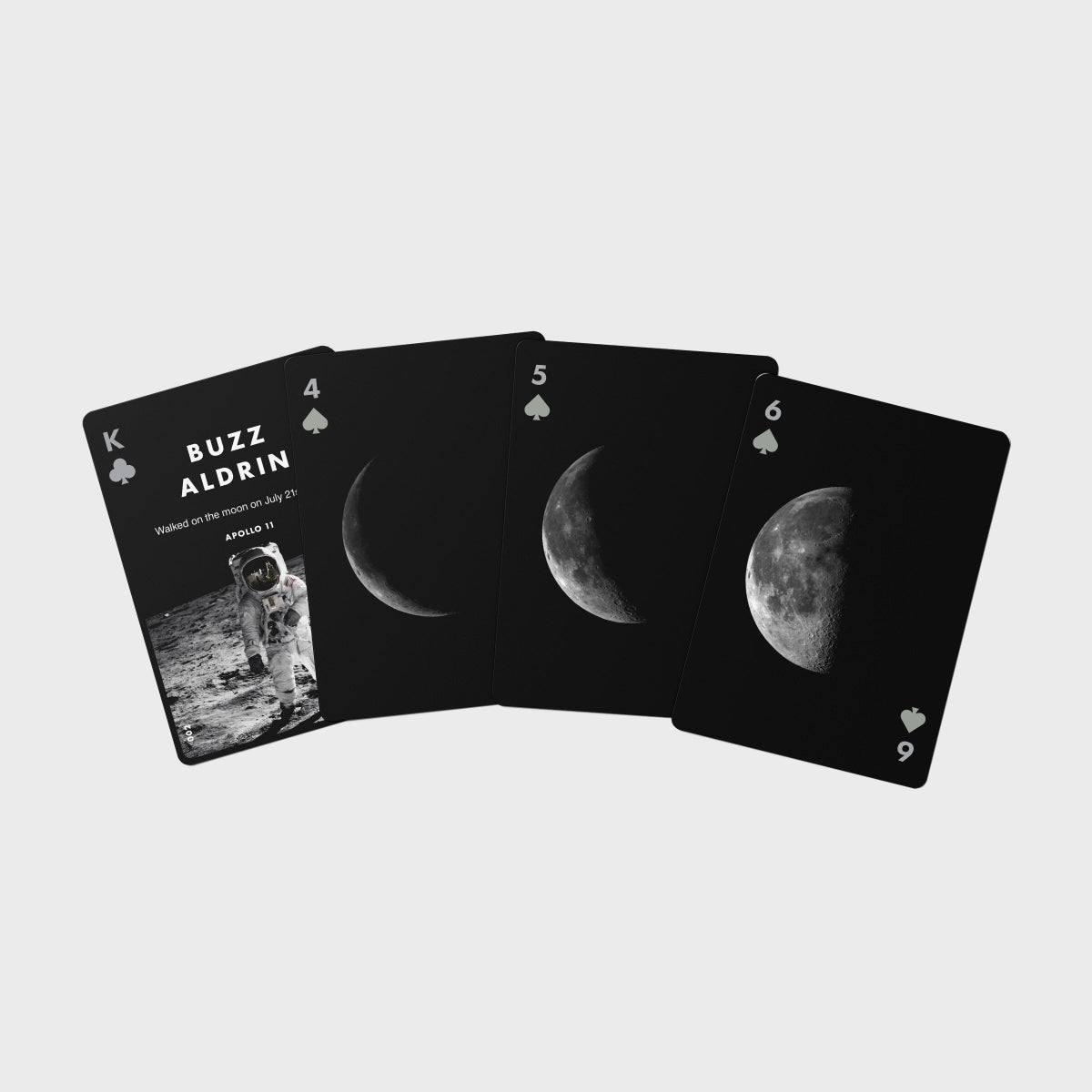 Playing cards with moon phases and astronaut imagery on a light gray background