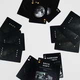 Black playing cards with moon imagery and text on a light gray background