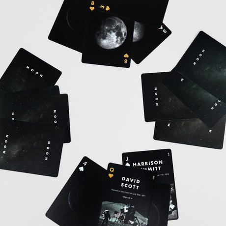 Black playing cards with moon imagery and text on a light gray background