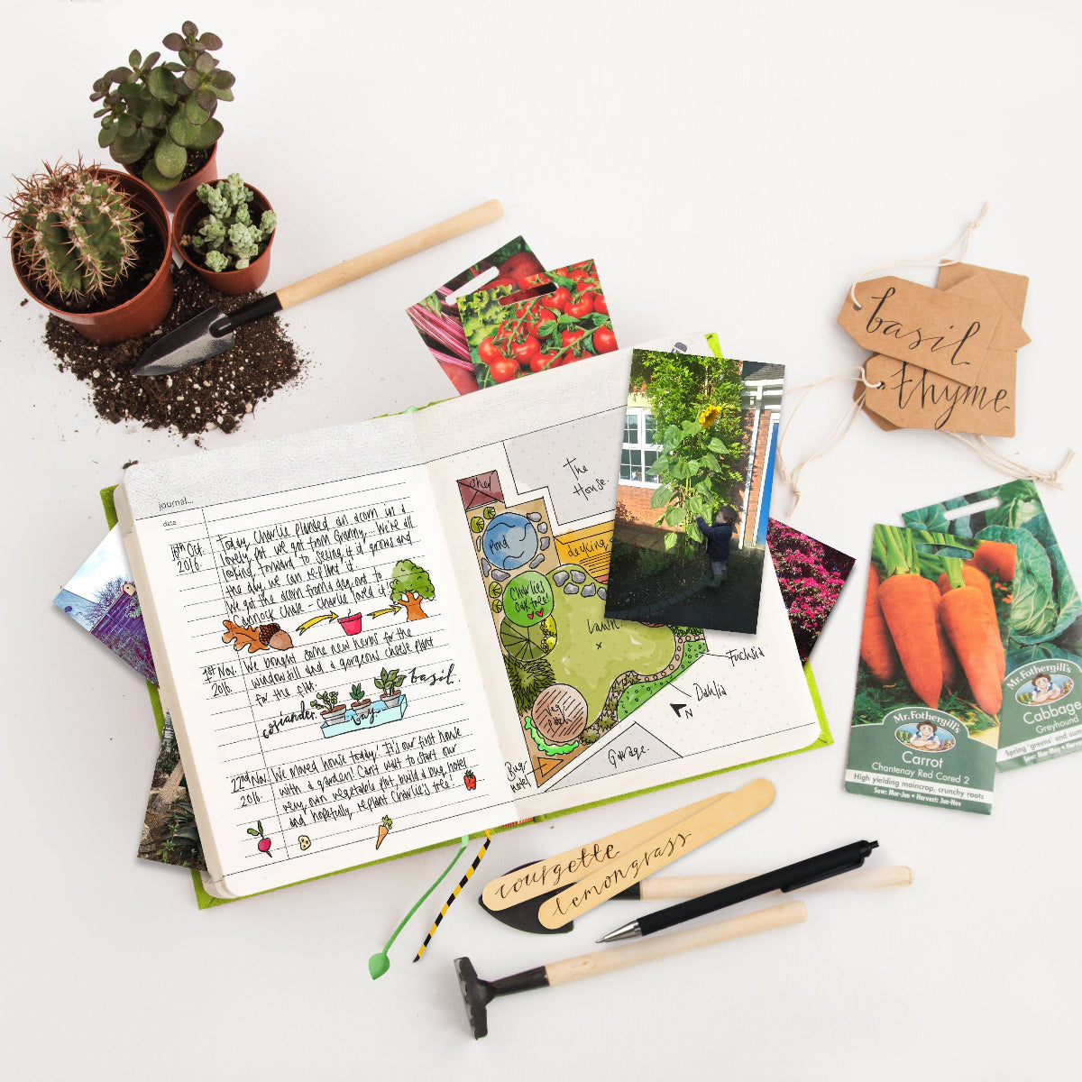 Gardening supplies including seed packets, a notebook, and a pen on a white surface.