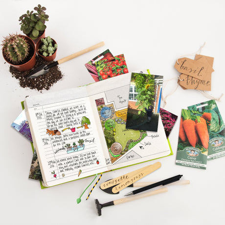 Gardening supplies including seed packets, a notebook, and a pen on a white surface.
