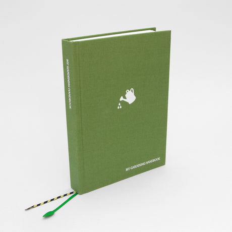 Green notebook titled 'My Gardening Handbook' with a white watering can logo on a white background