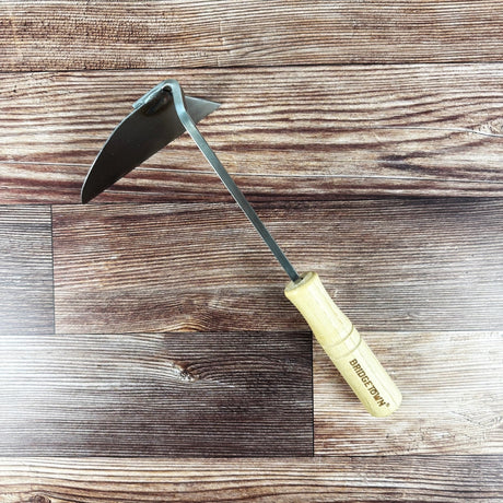garden hoe with a wooden handle on a wooden surface