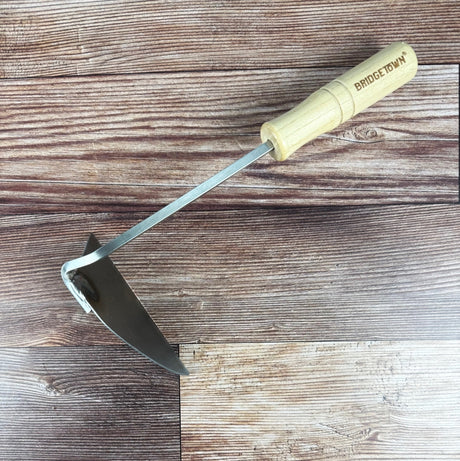 garden hoe with a wooden handle on a wooden surface