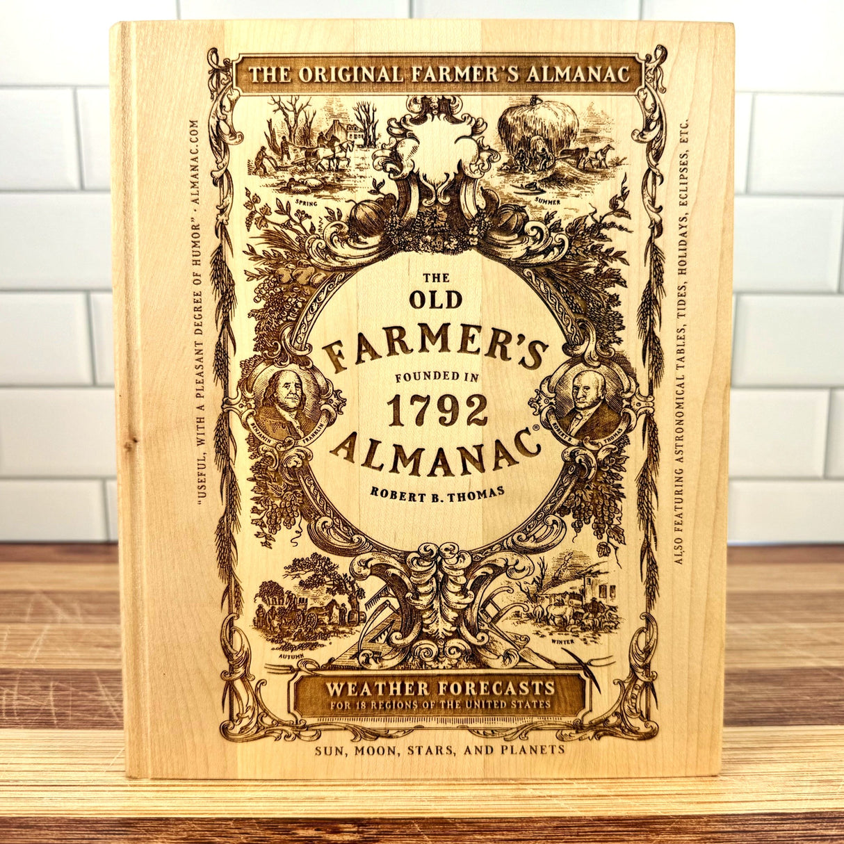 The Old Farmer's Almanac book on a wooden surface with a white tiled wall background