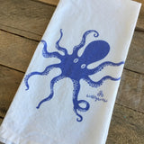 White towel with blue octopus design on a wooden surface