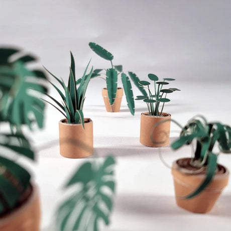 Set of paper potted plants on a light surface with a neutral background