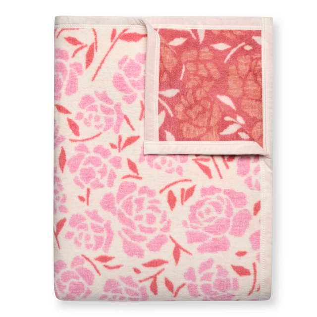 Floral patterned blanket with pink and red flowers on a white background
