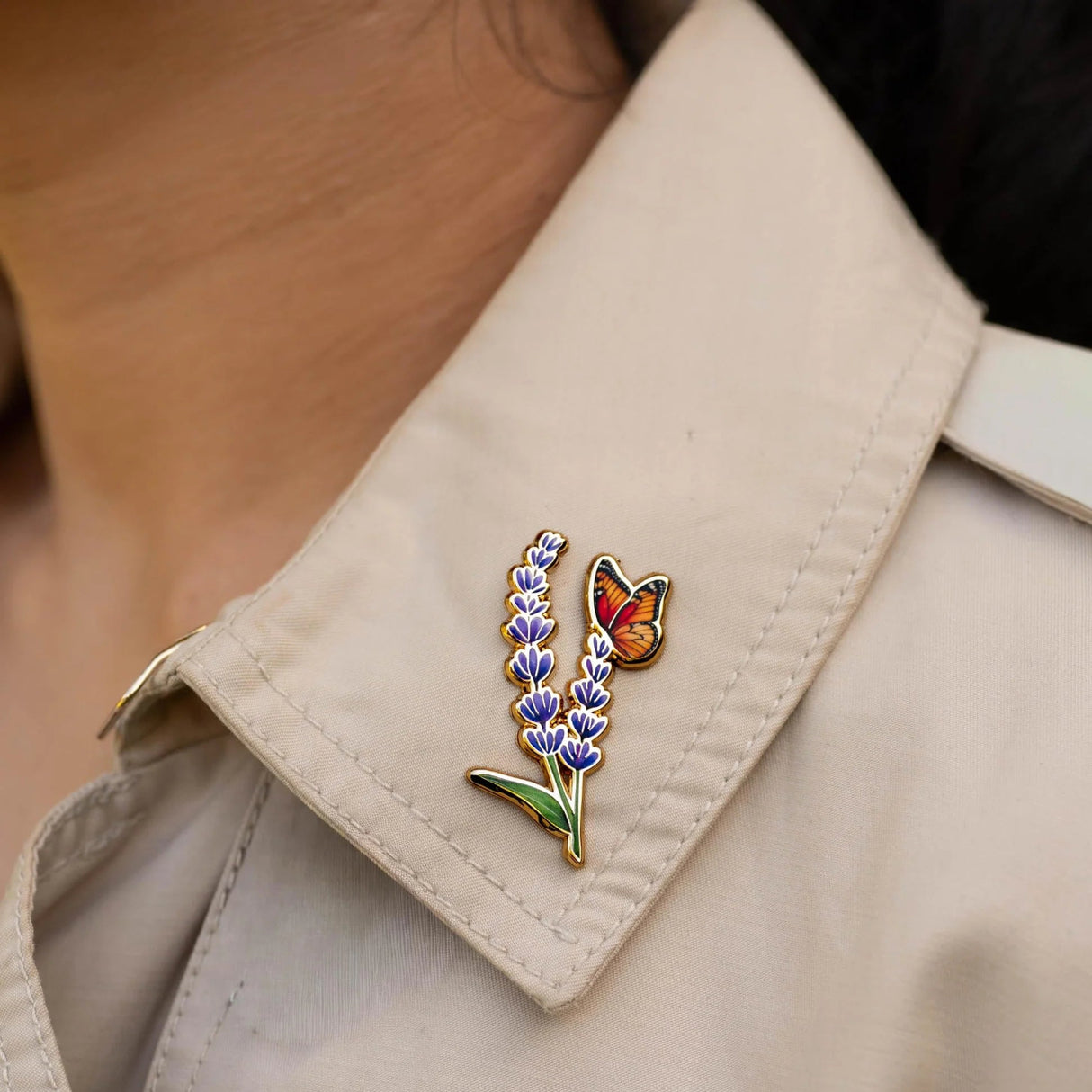 Pin with lavender and butterfly design on a beige jacket