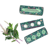 Bath bomb packaging with basil plant on a white background