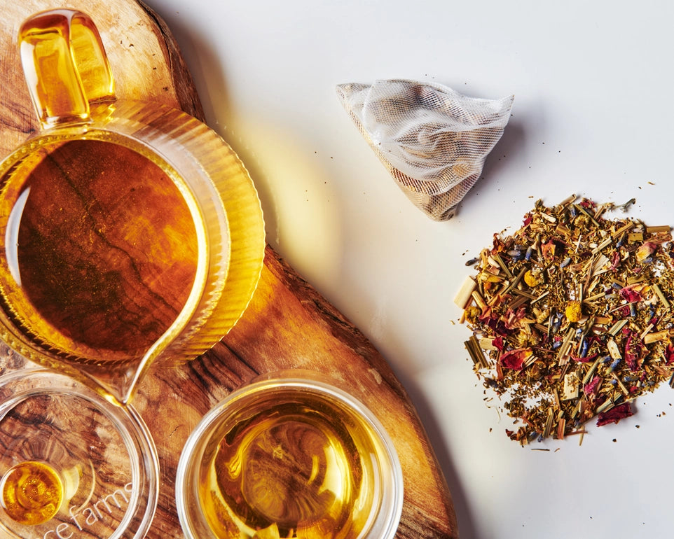 Tea cup with tea leaves and a tea bag on a wooden board