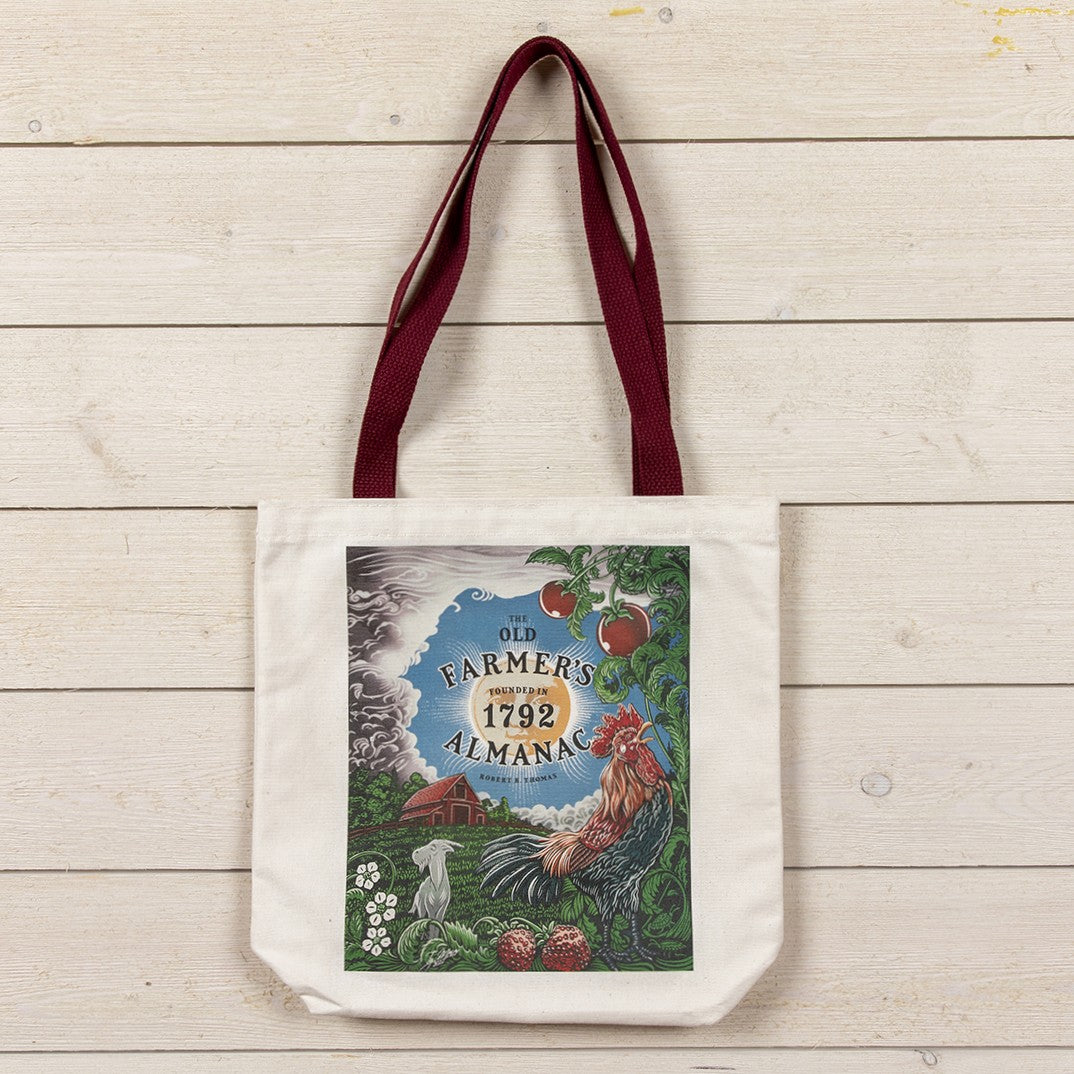 Tote bag with 'Old Farmer's Almanac' design with farm illustration with a rooster on a wooden surface