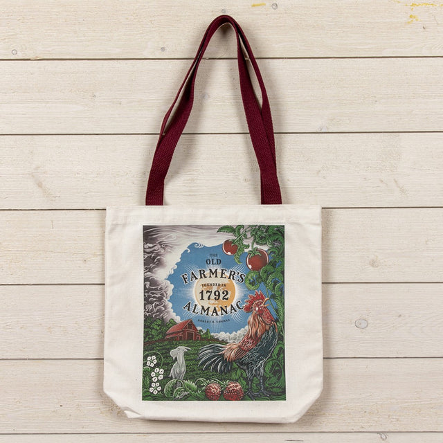 Tote bag with 'Old Farmer's Almanac' design with farm illustration with a rooster on a wooden surface