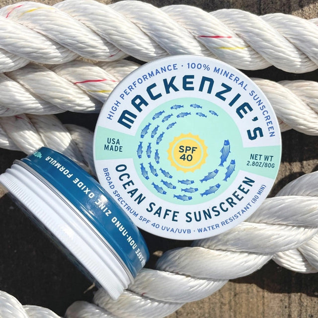 two tins of ocean safe sunscreen atop white coiled marine rope