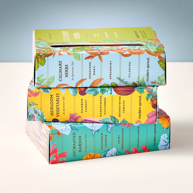 Stack of colorful gardening seed boxes on a light background