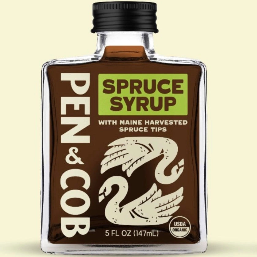 Bottle of Pen & Cob Spruce Syrup on a beige background