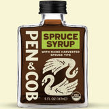 Bottle of Pen & Cob Spruce Syrup on a beige background