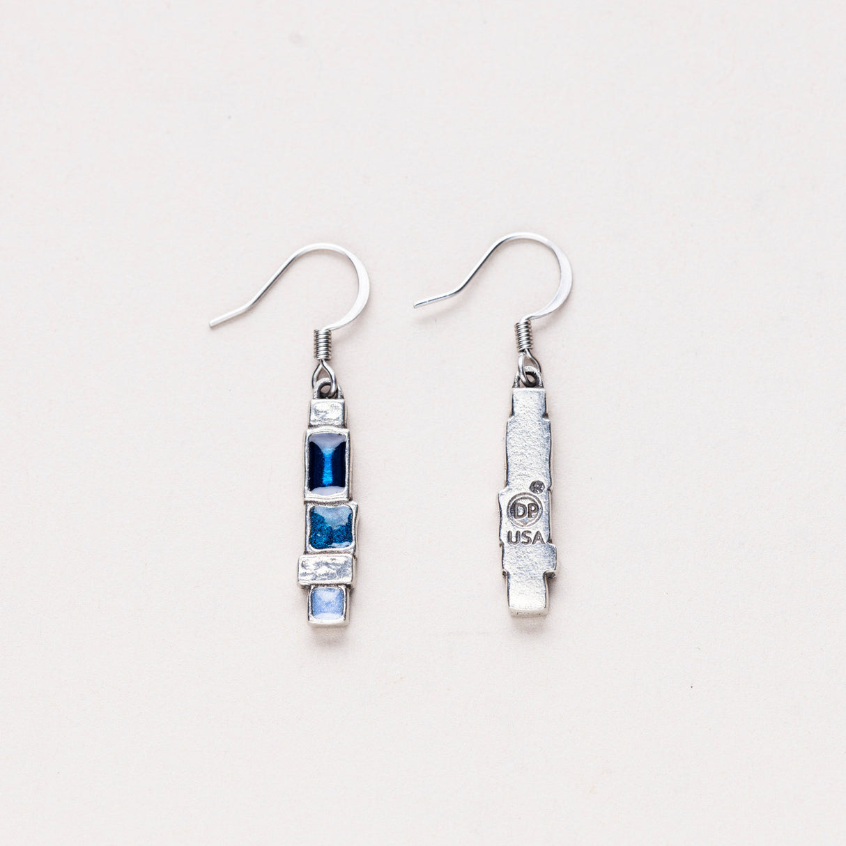 A pair of Danforth Pewter Stepping Stone earrings, with one earring flipped to reveal the maker's mark on the back, highlighting the handcrafted pewter design