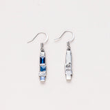 A pair of Danforth Pewter Stepping Stone earrings, with one earring flipped to reveal the maker's mark on the back, highlighting the handcrafted pewter design