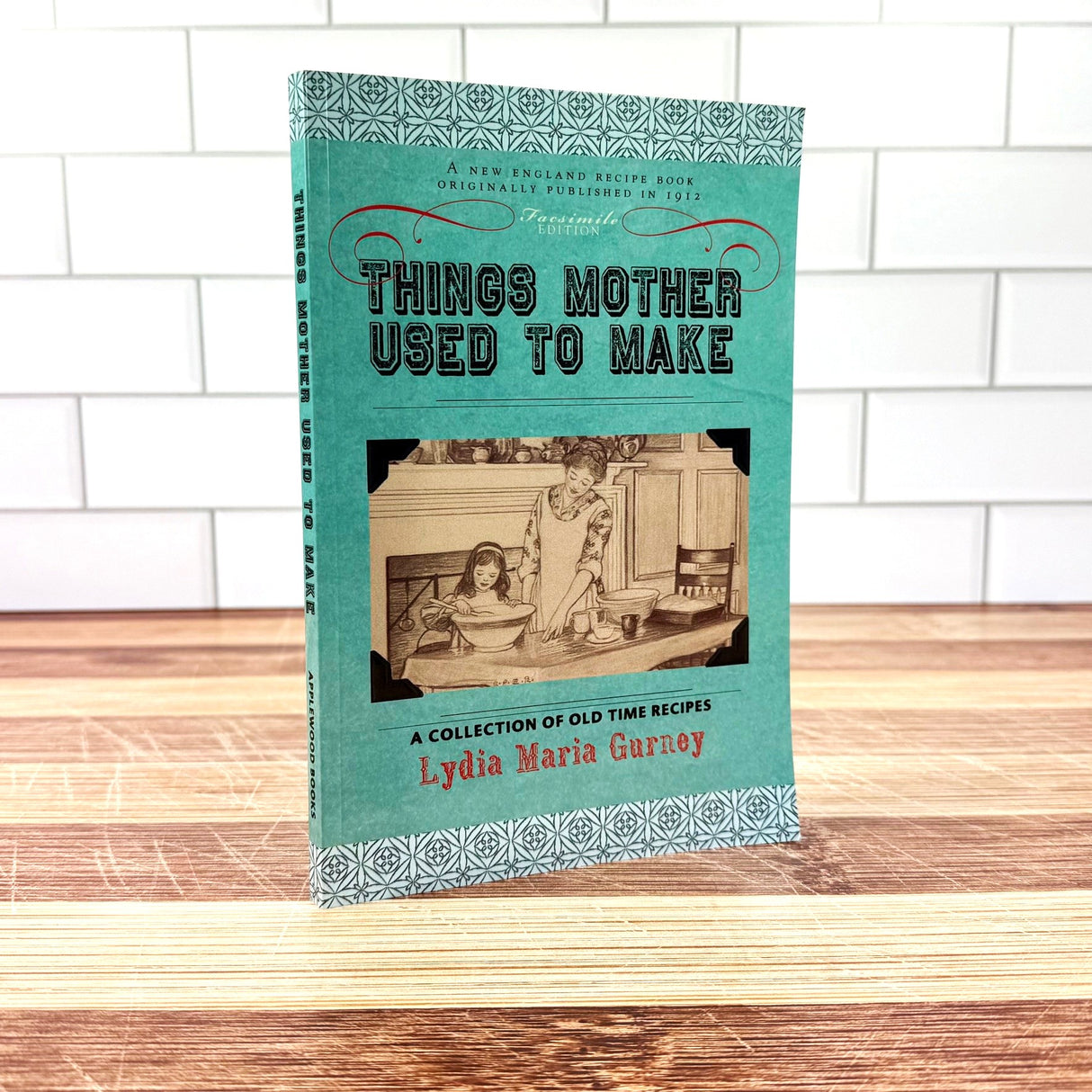 Book titled 'Things Mother Used to Make' by Lydia Maria Gurney on a wooden surface with a white tiled wall background.