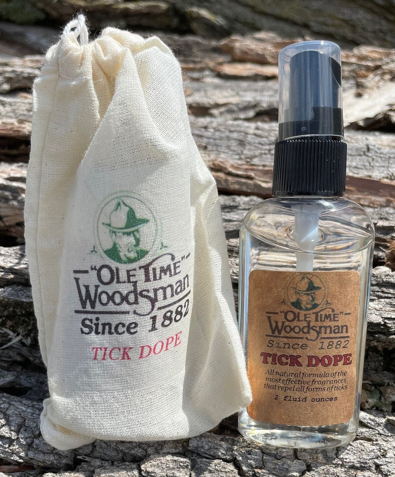 Tick dope bottle with drawstring bag packaging on a log