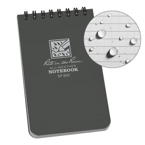 a gray top spiral notebook with a circle showing a page from the notebook with water beading on the surface showing the waterproof nature of the paper