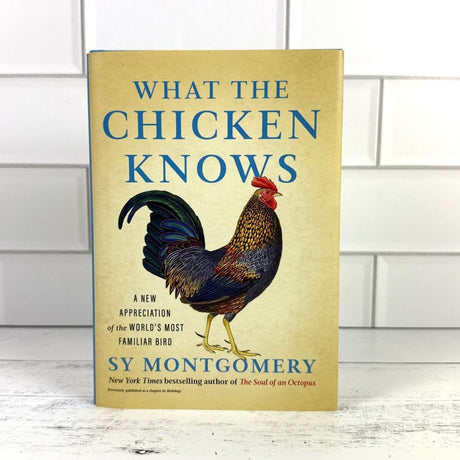 Book titled 'What the Chicken Knows' by Sy Montgomery with a rooster illustration on a beige background.